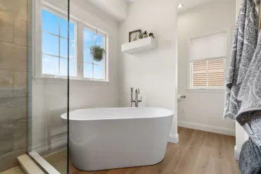 Freestanding soaking tub in a Landisville, PA bathroom remodel with a matte black floor-mount faucet and window nook.