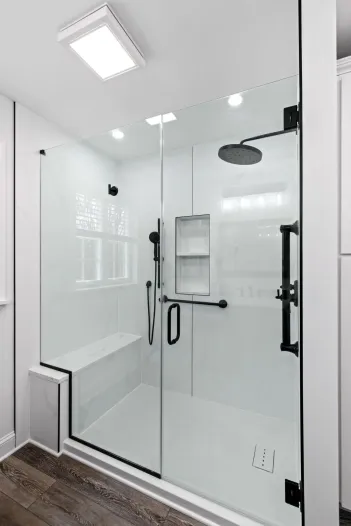 lititz, PAAlt text: Walk-in shower remodel in Lititz, PA with a black-framed sliding glass door, black base, and matte black fixtures. Caption: This Lititz, PA shower remodel features a sleek black-framed sliding glass enclosure paired with a matching black shower base and matte black hardware, including a handheld sprayer and built-in shelving. Light wood-look flooring and white wall tile keep the space bright while the black accents add contrast. Next photo whenever you're ready.downtown lancaster, PAThought processThought processAlt text: Bathroom remodel in downtown Lancaster, PA with black-framed mirrors reflecting a marble-tiled shower with sliding glass doors. Caption: This downtown Lancaster, PA bathroom remodel features sleek black-framed mirrors above a white quartz vanity, with polished chrome faucets and a glass-enclosed shower with marble-look tile reflected behind. A pendant light adds a clean, modern touch overhead. Next one whenever you're ready.Thought processThought processAlt text: Marble-tiled walk-in shower with dual black rainfall showerheads, built-in bench, and black-framed glass door. Caption: This spa-style walk-in shower features floor-to-ceiling marble-look tile, dual black rainfall showerheads, a built-in bench with a book-matched marble slab, and recessed niche shelving. Matte black hardware and a black-framed glass door contrast beautifully against the white marble, while a window brings in natural light and a wooded view. Next one whenever you're ready — and let me know if you want a location added to this one.Thought processThought processAlt text: Bathroom remodel with dark wood double vanity, white countertop, black-framed mirrors, and a tiled glass shower. Caption: This bathroom remodel pairs a dark wood double vanity with a white quartz countertop and black-framed mirrors, set against warm terracotta walls. Brass and nickel wall sconces add a mixed-metal touch, while the glass-enclosed shower features square tile walls, a built-in bench, and a window for natural light. Next one whenever you're ready.Alt text: Frameless glass shower with black hardware, built-in bench, and round black rainfall showerhead over marble-look tile.