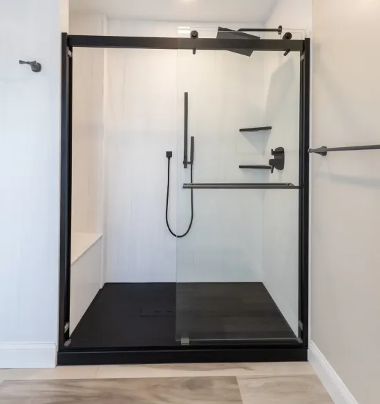 Walk-in shower remodel in Lititz, PA with a black-framed sliding glass door, black base, and matte black fixtures.